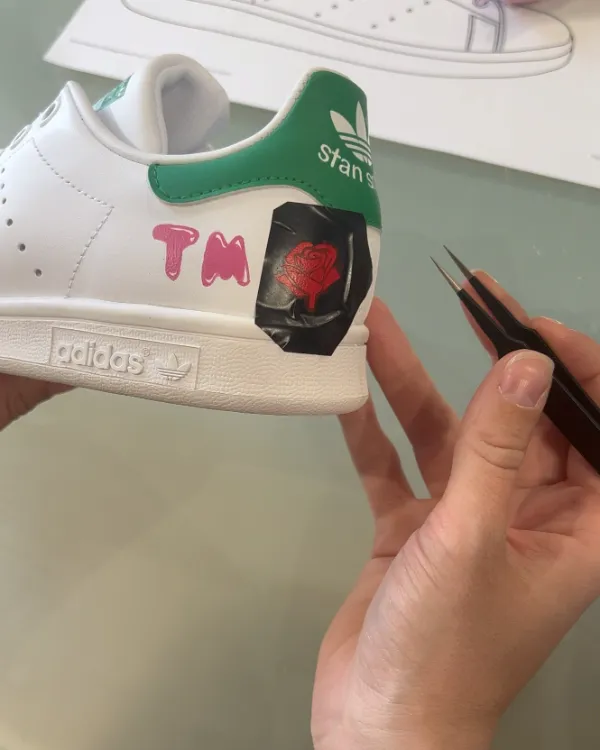 Une Stan Smith personnalisée pendant l'atelier : une rose et des initiales peintes au talon