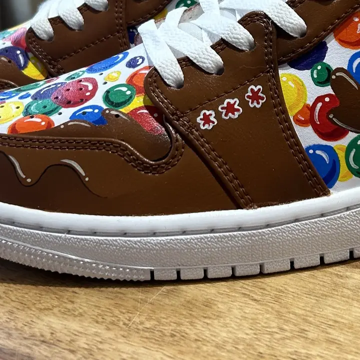 Gros plan d'une sneaker peinte de bonbons colorés et de chocolat