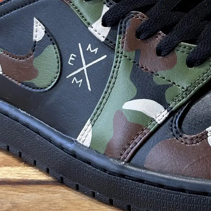 Gros plan d'une sneaker peinte en camouflage vert et marron